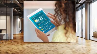 Young woman with tablet computer using weather forecast application at home Wall mural