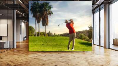 golf shot man. professional golf swing. Golf player teeing off. Front view of golfer finishing swing with a smile. Full length of golfer playing on the course. Golfer hitting golf shot with club Wall mural