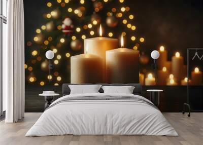 Two lit candles are placed on a wooden surface with the warm, bokeh lights of a decorated Christmas tree in the background. christmas candle and christmas tree Wall mural