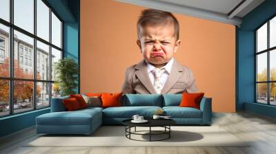 Portrait of unhappy little boy looking at camera isolated over yellow background Wall mural