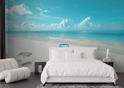 Mobile phone mockup on white sand with blue sea background. Wall mural