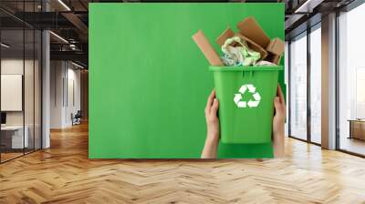 Hands Holding Green Recycling Bin Filled With Cardboard and Plastic Wall mural