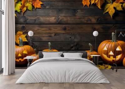 Rustic Halloween image with Jack o' Lantern pumpkins and dried autumn leaves against a wooden background.  Wall mural