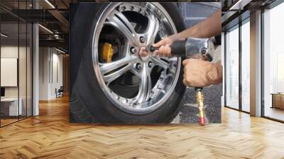 Auto mechanic changing car wheel Wall mural