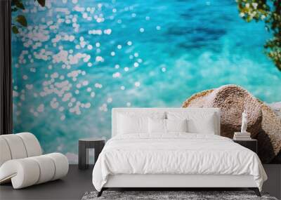 Straw Hat on Cliff Overlooking Turquoise Ocean with Sunlit Water Reflections Wall mural