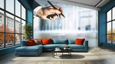 Man hand with pen working with abstract virtual financial graph on blurred office background, forex and investment concept. Multiexposure Wall mural