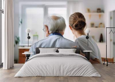 Back view of a nurse with elderly man at home Wall mural