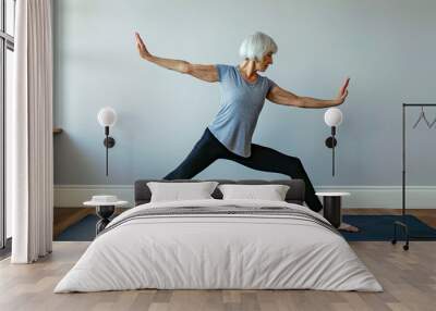 Senior woman doing yoga in her living room Wall mural