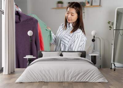 Asian Woman Selecting Clothes from Rack for Casual Chic Wall mural