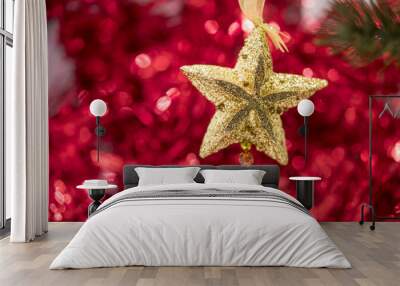 Christmas star ornament hang on tree branch with red bokeh backg Wall mural