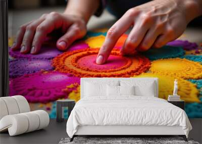 A vibrant, colorful sand art mandala is created by hands, showcasing intricate patterns and textures in purple, orange, pink, and yellow hues. Wall mural