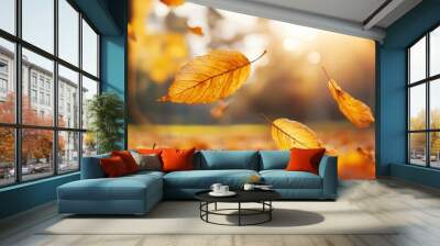 Golden autumn leaves falling in sunlight, creating a warm and vivid seasonal atmosphere in a serene outdoor landscape. Wall mural