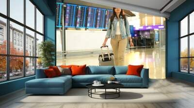 Asian woman traveler walking in airport terminal. Wall mural