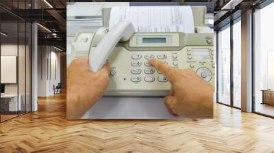 Hand man are using a fax machine send paper in the office Business concept  Wall mural