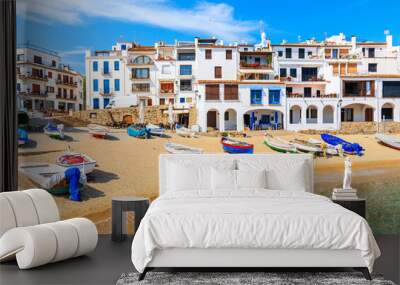 Fishing boats on beach in Port Bo with colorful houses of old town of Calella de Palafrugell in background, Catalonia, Spain Wall mural