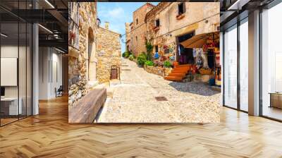 TOSSA DE MAR OLD TOWN, SPAIN - JUN 3, 2019: Shop with souvenirs and traditional crafts in old town of Tossa de Mar with stone houses, Costa Brava, Spain. Wall mural