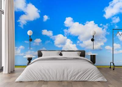 White sunny clouds on blue sky and green farming fields, Sylt island, Germany Wall mural