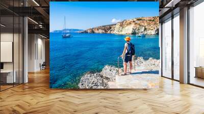 Young woman tourist looking at Rema beach in beautiful sea bay, Kimolos island, Cyclades, Greece Wall mural