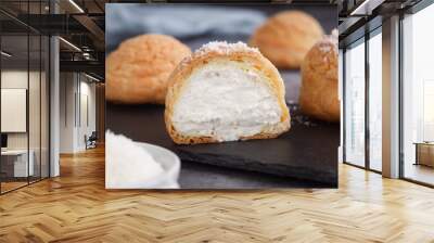 A French cream puff crack bun (Choux au Craquelin) in a plate, cut in a half filled with cream coconut filling topped with coconut grated. It's a dessert base of savory choux dough bun  Wall mural