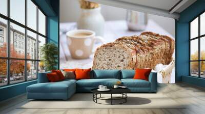 A loaf of multi grains and cereals healthy flourless bread with low calories and vegan in a bamboo basket, cup of coffee in background. High in proteins. Paleo and ketogenic diet  Wall mural