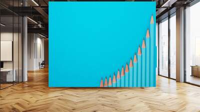 Flat lay of blue pencils show as graph chart on blue background with copy space. Creative idea, education, business, finance profit growth or success target concept. Wall mural