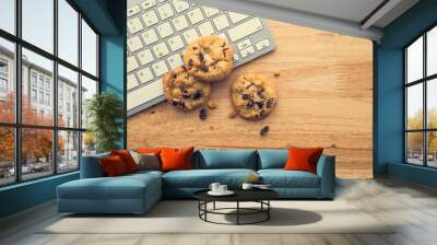 Flat lay of white chocolate chip cookies on keyboard computer on wooden table background copy space. Cookies website internet homepage policy accpeted or blocks concept. Wall mural