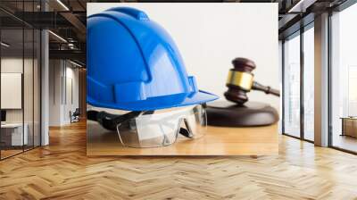 Hammer judge gavel with construction hat helmet, worker safety glasses on wooden table. Labour law concept. Wages, overtime pay, welfare, occupational safety, health, environment, severance pay. Wall mural