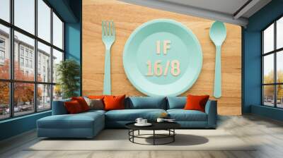 IF (Intermittent Fasting) 16 and 8 diet rule and weight loss concept. IF 16 and 8 letter on blue plate, spoon and fork on wooden table background. Wall mural