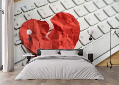 Red broken heart paper on white keyboard computer background. Online internet romance scam or swindler in website application dating concept. Love is bait or victim. Wall mural