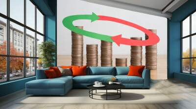 Stack coins and arrow red green curve graph chart volatility up and down on wooden table background. Business, financial and investment concept. Risk, fluctuation in stock market and cryptocurrency. Wall mural