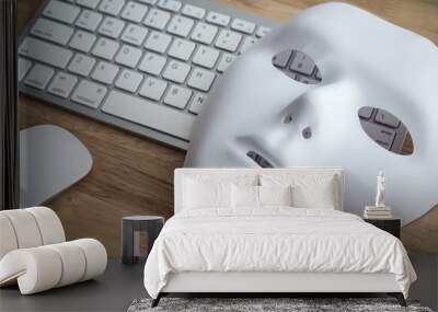 White scary half face mask, keyboard and mouse on wooden table background in dark tone. Hacker, cybercrime, romance scam and online security concept. Wall mural