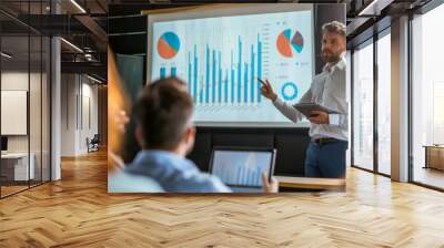 A businessman presenting a profit and loss graph during a corporate presentation. Wall mural