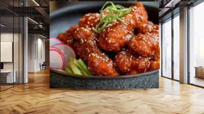 A detailed shot of crispy Korean fried chicken coated in a sweet and spicy sauce, served with a side of pickled radishes, emphasizing the dish's crunchy texture and bold flavors. Wall mural