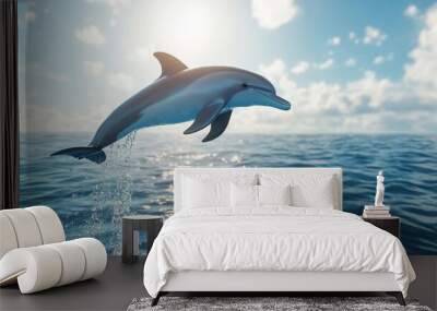 A playful dolphin leaping out of crystal-clear blue water against a bright sunny sky, capturing the grace and agility of these marine mammals in their natural habitat. Wall mural