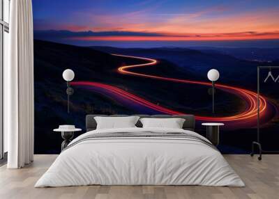 A winding road illuminated by car headlights against the backdrop of a twilight sky Wall mural