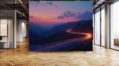 A winding road illuminated by car headlights against the backdrop of a twilight sky Wall mural