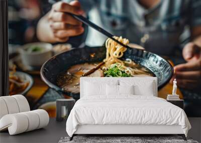 Person enjoying a traditional Japanese ramen noodle soup with sliced pork, bamboo shoots, and soft-boiled egg Wall mural