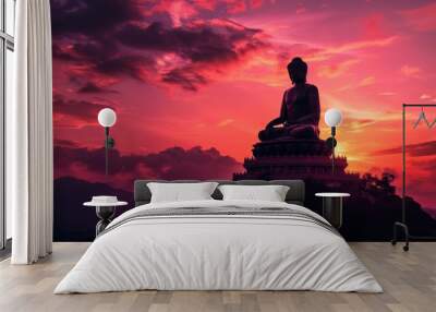 Silhouette of a large Buddha statue at sunset with vibrant orange and pink sky. Wall mural