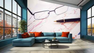 Pen and glasses on financial chart business concept analysis of sales plan business report business work station with paperwork Wall mural