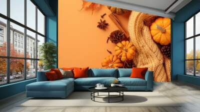 Autumn Decorations Featuring Pumpkins, Pine Cones, and a Cozy Sweater on an Orange Background Wall mural