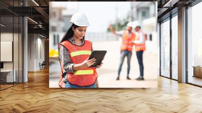 Construction worker, Engineering or architect woman using digital tablet for work at construction site , Engineer female inspection at real estate project. Wall mural