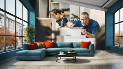 Senior caucasian man specialist worker measuring white shelf furniture in wood workshop, Small business in wood furniture industry. Wall mural