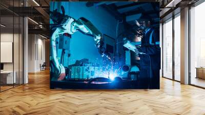 Specialist robotic engineers maintenance and control robot arm in factory warehouse, Testing new innovation automation robot for industrial. African american man teamwork working with welding machine. Wall mural