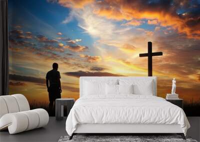 Silhouette of a Christian figure standing over a cross in a meadow at sunset , Easter, religious, concept, Christian, silhouette Wall mural