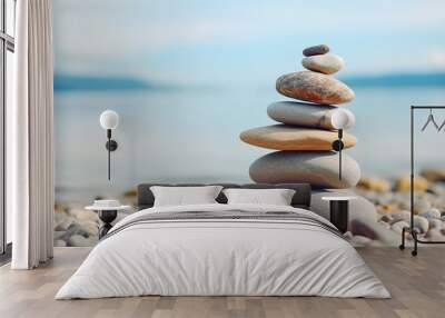 Balanced pebble pyramid silhouette on the beach with the ocean in the background. Zen stones on the sea beach, meditation, spa, harmony, calmness, balance concept Wall mural