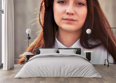 Portrait of a young pretty girl in a light shirt and with her ha Wall mural