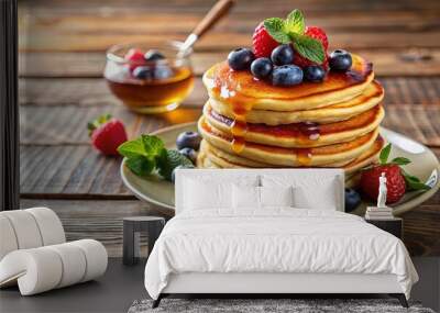 Fluffy pancakes with maple syrup and fresh berries on a cozy wooden table Wall mural