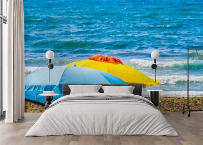 yellow and white and blue umbrellas with the blue sea in the background, symbols of summer Wall mural