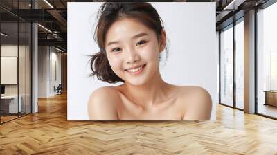 Beautiful korean model showing her fresh skin, smiling and looking at the camera, isolated on a white background Wall mural