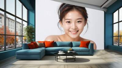 Beautiful korean model showing her fresh skin, smiling and looking at the camera, isolated on a white background Wall mural